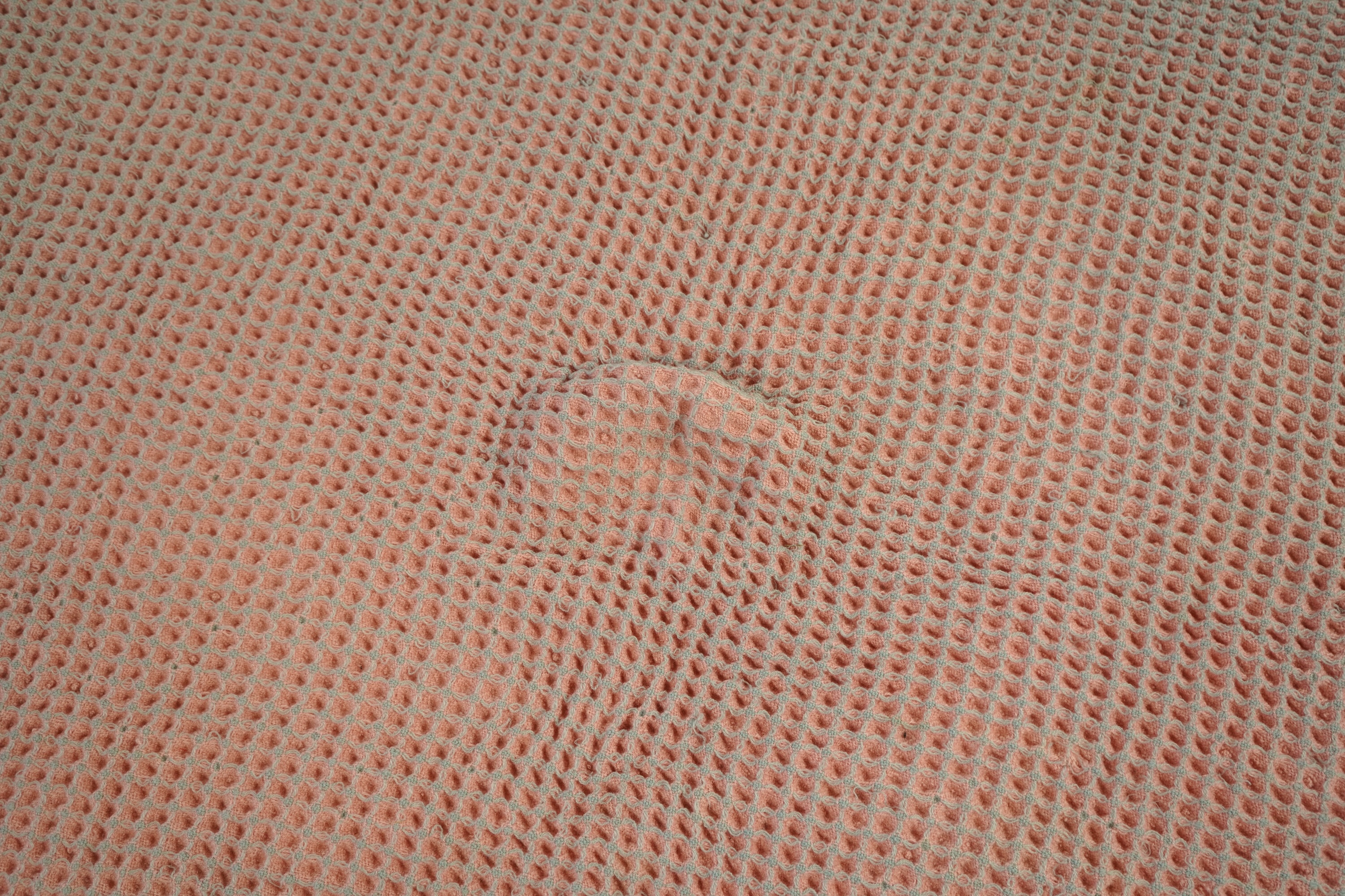 An unusual pink and grey honeycomb woven wool Welsh blanket. 194cm x 176cm. Condition - various threads have pulled and there is a small stain.